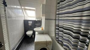 a small bathroom with a toilet and a sink at Pension Highway - Bünde Vincke Straße 11 in Bünde