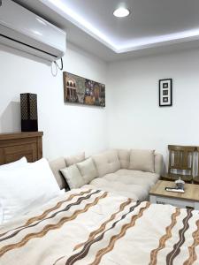 a bedroom with a bed and a couch at Velmora Villas Room 12 in Abu Dhabi