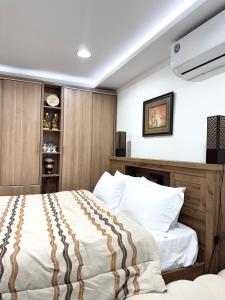 a bedroom with a large bed with a wooden headboard at Velmora Villas Room 12 in Abu Dhabi