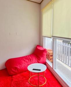 a red couch and a table in a room with a window at Teras Candi Villa in Diyeng