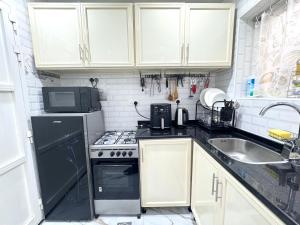 a small kitchen with a sink and a stove at Velmora Villas Room 12 in Abu Dhabi