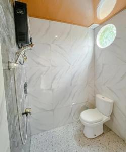 a small bathroom with a toilet and a shower at Teras Candi Villa in Diyeng