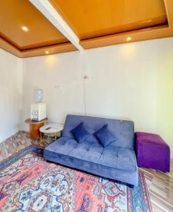 a blue couch in a living room with a rug at Teras Candi Villa in Diyeng