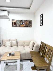 a living room with a couch and a table at Velmora Villas Room 12 in Abu Dhabi +6 photos