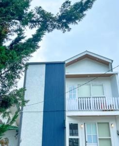 a white house with a blue column at Teras Candi Villa in Diyeng