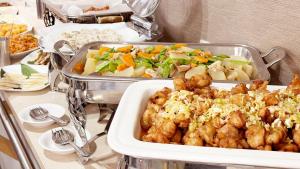 a buffet with several trays of food on a table at Hotel Green Palace in Sendai +12 photos