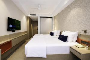 a hotel room with a large bed and a tv at Grand Continent Hotel, Near Sector 44, Gurugram in Gurgaon