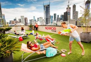 a group of people laying on the grass with a frisbee at Space Hotel in Melbourne