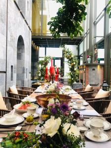 a long table with plates and flowers on it at Wumo Qinglu Snow Mountain Museum Hotel in Baisha
