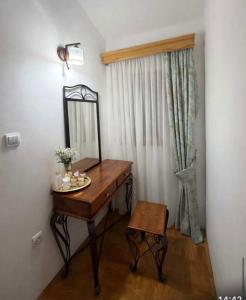 a dressing table with a mirror and a stool at Villa Jakov in Podgorica