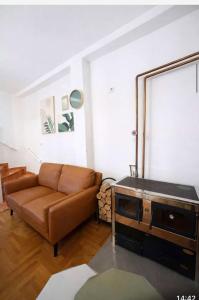 a living room with a brown couch and a table at Villa Jakov in Podgorica +11 photos