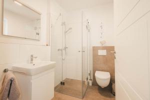 a bathroom with a shower and a toilet and a sink at Boddenruh in Fuhlendorf +20 photos