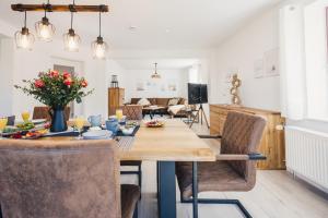 a dining room and living room with a table and chairs at Gartenidyll in Zingst