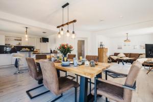 a dining room and living room with a table and chairs at Gartenidyll in Zingst