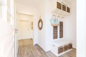 a hallway with white walls and a staircase with a white stair case at Boddenbrise in Bresewitz