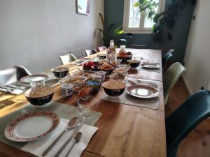 a long wooden table with plates and dishes on it at B&B Monte Adone in Santa Cecilia