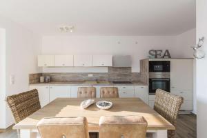a kitchen with a wooden table and chairs at Boddenbrise in Bresewitz
