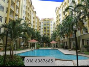 a large swimming pool with palm trees and buildings at Stay 707 Apartment , homestay Melaka , unit 1-11 in Malacca