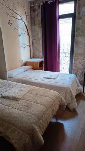 two beds in a hotel room with a window at Alfonso XII in Redondela