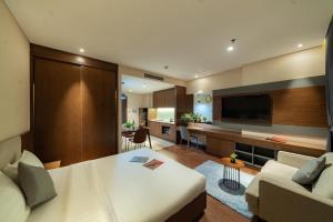 a bedroom with a large bed and a living room at DHTS Business Hotel & Apartment in Ho Chi Minh City +58 photos