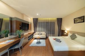 a hotel room with a bed and a desk at DHTS Business Hotel & Apartment in Ho Chi Minh City