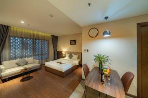 a room with a bed and a couch and a table at DHTS Business Hotel & Apartment in Ho Chi Minh City