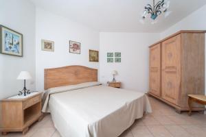 a bedroom with a large bed and a wooden cabinet at Rubens in Alghero