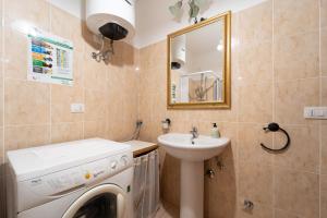 a bathroom with a washing machine and a sink at Rubens in Alghero +15 photos