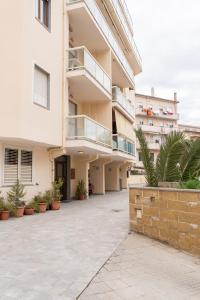 an apartment building with a courtyard with potted plants at Rubens in Alghero