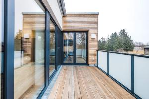 a wooden deck with glass doors on a house at Kranichruf in Müggenburg