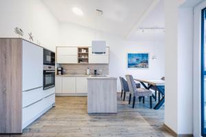 a kitchen with white cabinets and a table with chairs at Kranichruf in Müggenburg