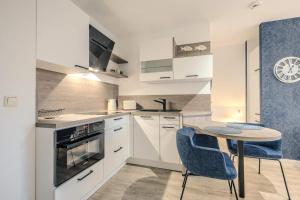 a kitchen with white cabinets and a table and chairs at Lee in Zingst