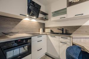 a kitchen with white cabinets and a stove top oven at Lee in Zingst