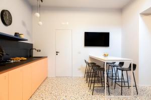 a kitchen with a white table and stools at Ghibellini Rooms in Palazzolo Acreide