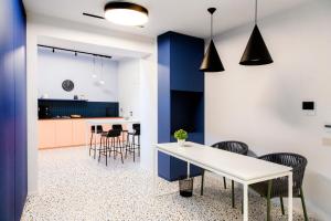 a kitchen and dining room with a white table and chairs at Ghibellini Rooms in Palazzolo Acreide