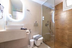 a bathroom with a toilet and a glass shower at ATH Airport Suites Free Shuttle From And To Athens Airport in Spata