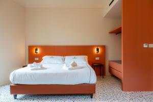 a bedroom with a large bed with white sheets at Ghibellini Rooms in Palazzolo Acreide