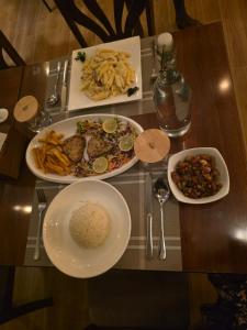 a table with plates of food on a table at Nikabliss Dhigurah in Dhigurah +39 photos