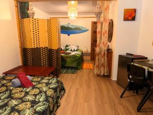 a room with a bed and a desk in a room at Hiva's Place climatisé terrasse vue sur mer -Huahine in HUH +32 photos