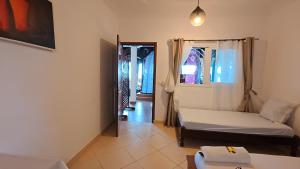 a living room with two beds and a window at Le Lagon Bleu in Antsatrakolo