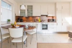 a kitchen with a wooden table and white cabinets at Neuland in Zingst