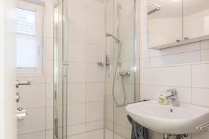 a white bathroom with a sink and a shower at Neuland in Zingst