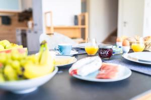 a table with plates of food and fruit on it at Ostseelodge zwei in Fuhlendorf