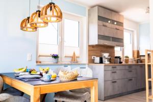 a kitchen with a table with a bowl of fruit on it at Ostseelodge zwei in Fuhlendorf