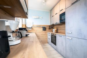 a kitchen with wooden cabinets and a counter top at Ostseelodge zwei in Fuhlendorf
