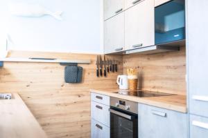 a kitchen with white cabinets and wooden walls at Ostseelodge zwei in Fuhlendorf +22 photos