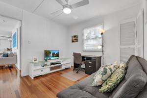 a living room with a couch and a desk at Janet Street in Noosaville