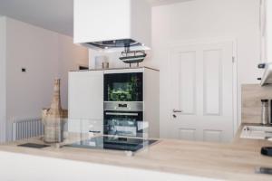 a kitchen with a glass counter with a tv in it at Sommersonne in Zingst +14 photos