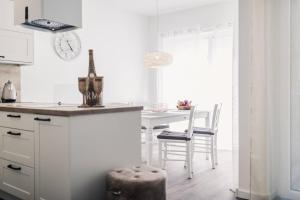 a kitchen with a table and a clock on the wall at Sommersonne in Zingst