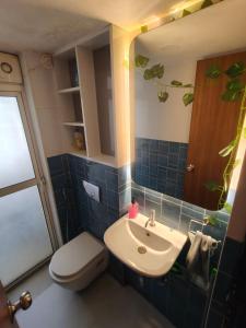 a bathroom with a sink and a toilet and a mirror at Staycation Couple friendly House in Thane